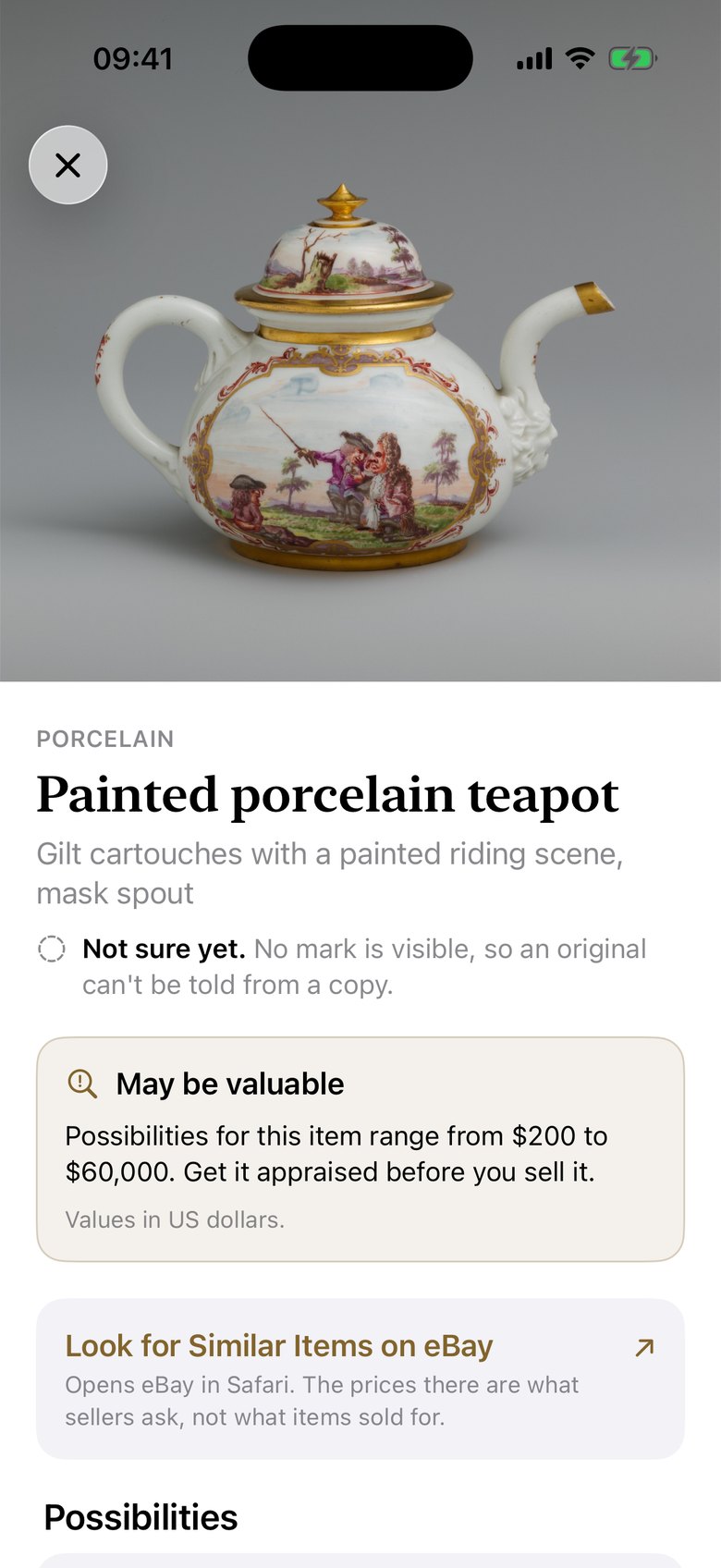 A painted porcelain teapot marked Not sure yet, with a card saying it may be valuable and should be appraised.